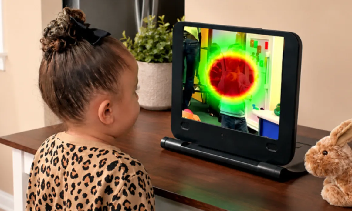 A young child watches the EarliPoint device while it maps her gaze as a heat map on screen